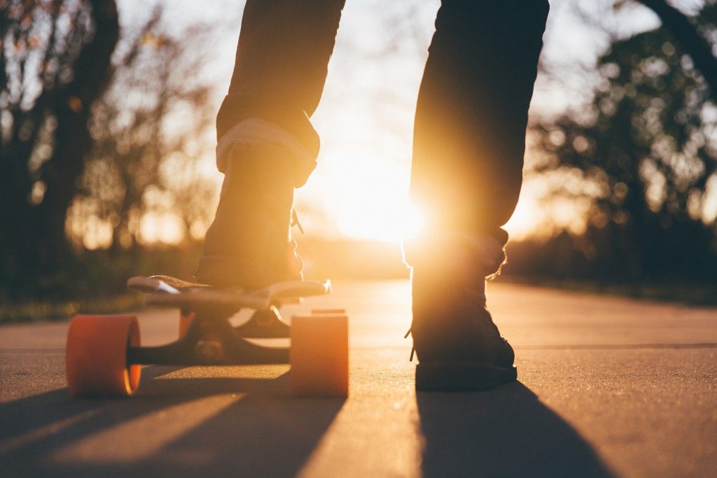 Skateboard und Schuhe im Sonnenuntergang